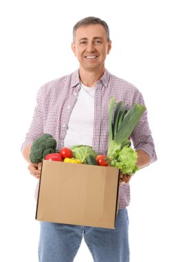 Beyaz arka planda bir kutu taze sebzeli olgun adam.