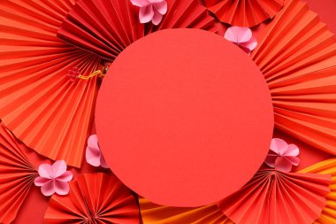 Hayranları olan boş bir kart ve kırmızı arka planda güzel çiçekler. Çin Yeni Yıl Kutlaması