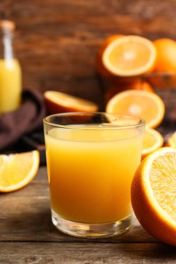 Ahşap arka planda bir bardak lezzetli portakal suyu.