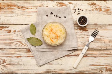 Lezzetli lahana turşusu ve beyaz ahşap arka planda baharatlar. Üst görünüm