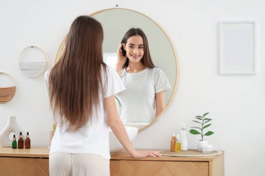 Genç kadın evde aynaya bakıyorum