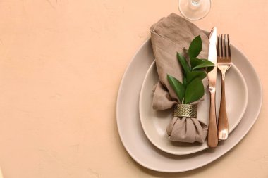 Bej arka planda taze yapraklarla güzel bir masa.