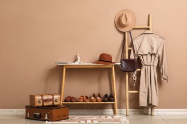 Modern koridorun iç tarafında kahverengi duvarın yanında duran ayakkabı ve merdiven için ayakta durun.