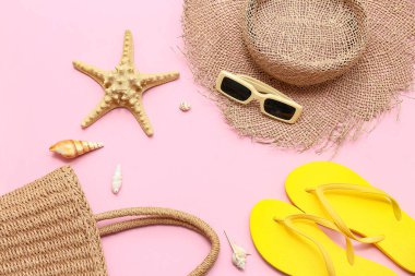 Pembe arka planda deniz kabukları, deniz kabukları ve plaj aksesuarları olan kompozisyon