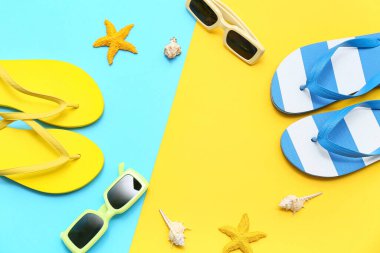 Renkli arka planda deniz kabukları, güneş gözlüğü ve parmak arası terlik kompozisyonu