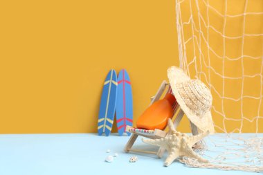 Denizyıldızı, güneş kremi, ağ, dekoratif iskemle ve arka planda şapka.