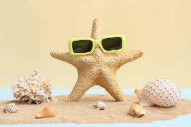 Deniz kabukları, deniz yıldızı, güneş gözlüğü ve kumlu kompozisyon renk arkaplanı
