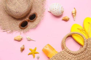 Deniz kabuklarından, deniz yıldızlarından ve pembe arka planda plaj aksesuarlarından yapılmış çerçeve