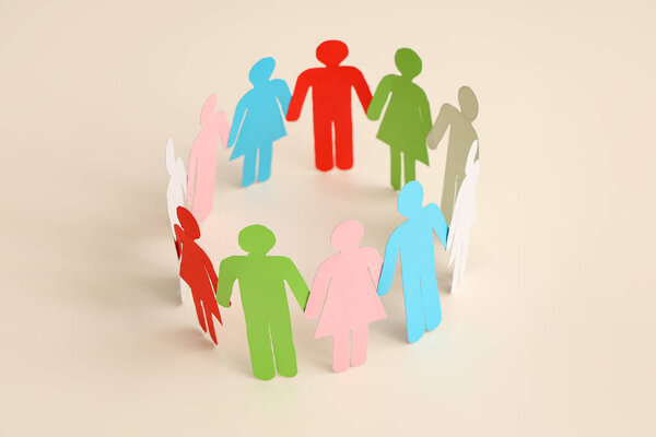 Бумажные человеческие фигуры образуют круг на светлом фоне. Концепция разнообразия и интеграции