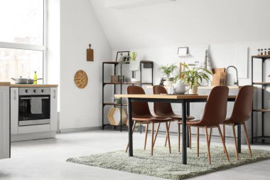 Mutfağın içinde yemek masası ve bitkiler var.