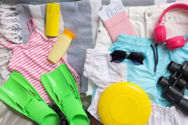 Arka planda giysiler, frizbi diski ve aksesuarlarla birlikte valizi aç, kapat