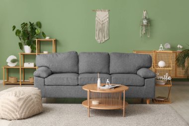 Gri kanepesi, sehpası ve büfesi olan şık bir oturma odası.