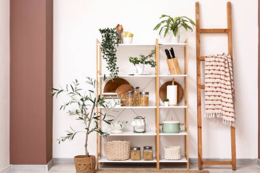 Ahşap raf ünitesi, merdiven ve bitkilerle birlikte mutfağın içinde.