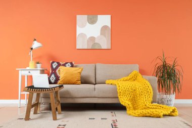 Oturma odasındaki rahat kanepe, masa ve dizüstü bilgisayar.