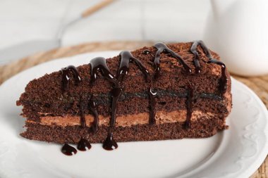 Hasır hasırın üzerinde lezzetli bir parça çikolatalı pasta, yakın plan.