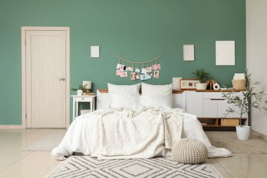 Yatak odasının içi, büyük rahat yatak odası, puf ve çekmeceler yeşil duvarın yanında.