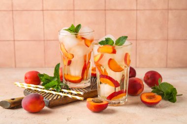 Lezzetli soğuk kokteyller ve pembe grunge masasında kayısılar, yakın plan.