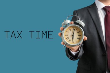 Çalar saat renk arka plan üzerinde tutan bir iş adamı. Zaman yönetimi kavramı