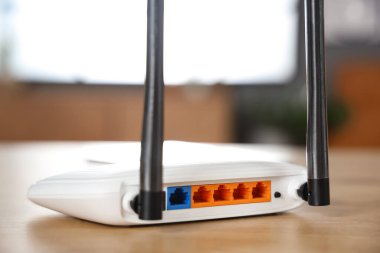 Modern Wi-Fi yönlendirici, ahşap masa, arka manzara.