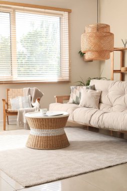 Rahat kanepesi, sehpası, koltuğu ve lambası olan bir oturma odası.