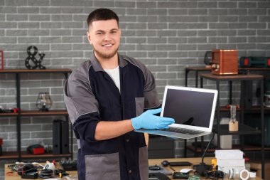 Servis merkezinde tamir edilmiş dizüstü bilgisayarı olan erkek teknisyen.