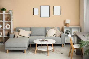 Rahat kanepesi, sehpası, işyeri ve perdesi olan şık bir oturma odası.