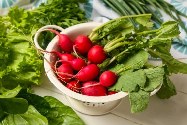 Taze turplu kolander ve hafif ahşap arka planda otlar.