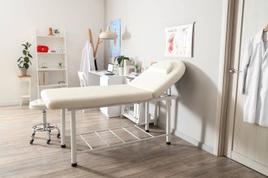 Kanepe, raf üniteleri ve doktorların iş yeri olan hafif tıp bürosu.