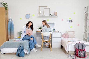 Yurt odasında kitap okuyan kız öğrenciler.