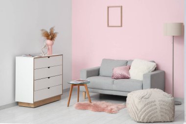 Sıcak kanepe, çekmeceler, sehpa ve puf oturma odasında.