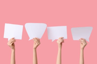 Pembe arka planda konuşma baloncukları olan kadın eller