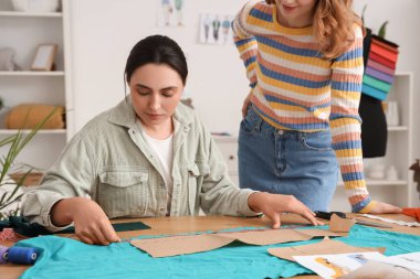 Atölyedeki masada çalışan kadın terziler