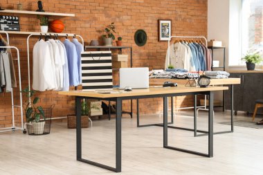 Erkek giyim mağazasındaki masada dizüstü bilgisayarlı alışveriş çantası.