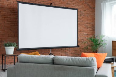 Projektör ekran ve kanepeli odanın içi.