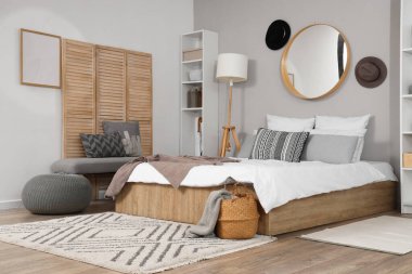 Ayna, şapka ve yumuşak banklı şık bir yatak odası.