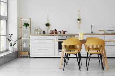 Mutfakta mumlar olan yemek masası.