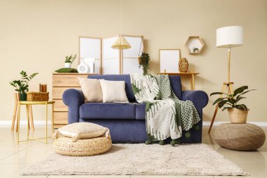 Oturma odasının içinde rahat bir kanepe ve puf.