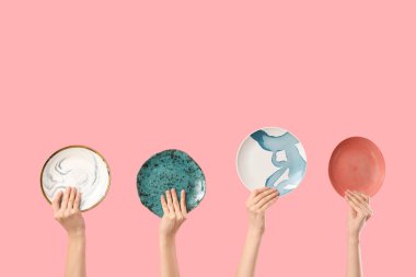 Pembe arka planda farklı plakalı kadın elleri