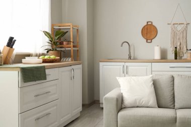 Mutfağın içinde tezgah, raf ünitesi ve kanepe var.