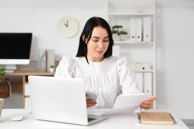 Masasında para iadesi formu olan genç bir iş kadını.