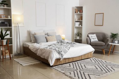 Şık lamba yatak odası, rahat yatak odası, gri koltuk ve parlak lambalar.