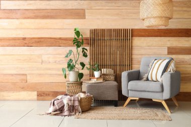 Katlanmış perdeli bir oda, rahat bir koltuk ve tahta duvarın yanında puf.