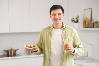 Mutfakta fıstık ezmesi ve tost kavanozu olan genç bir adam.