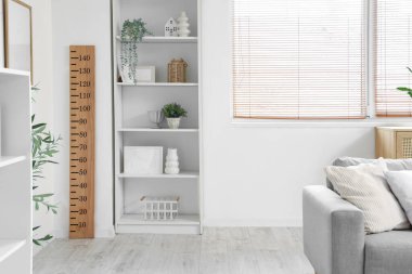 Kanepe, raf üniteleri ve pencereye yakın ahşap stadyumlu modern oturma odasının içi.