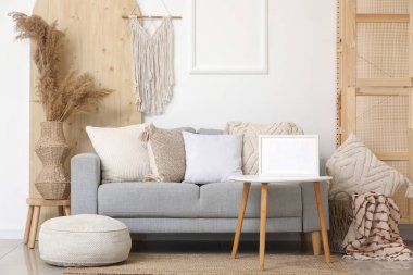 Gri kanepeli ve kahve masasında boş çerçeveli şık bir oturma odası.