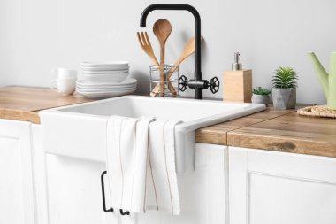 Mutfakta lavabo, çatal bıçak ve temiz havluyla tezgah, yakın çekim.