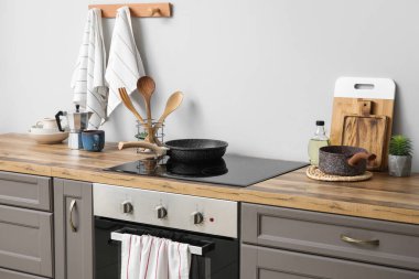 Mutfakta elektrikli ocak, mutfak gereçleri ve temiz havlular var.