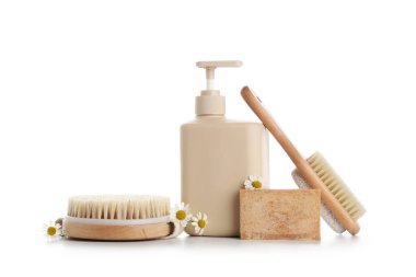 Duş jeli, masaj vücut fırçası ve beyaz arka planda izole edilmiş sabun çubuğu içeren kompozisyon