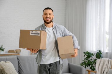 Young man with parcel boxes at home