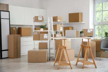 Deponun içinde iş yeri, raf üniteleri ve paket kutuları var.